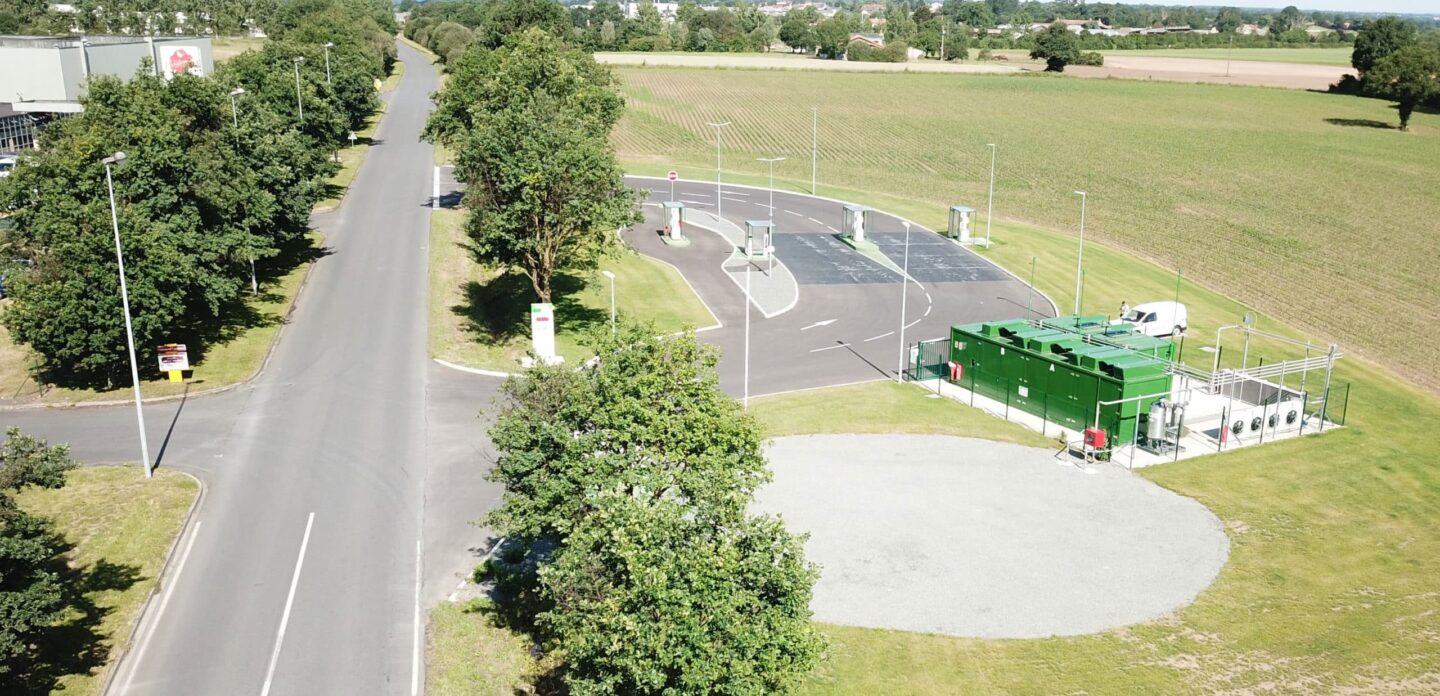 Vue aérienne d'une station d'avitaillement en bord de route, avec ses unités de compression